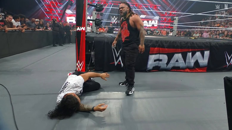 Fatu standing over Reigns on the outside