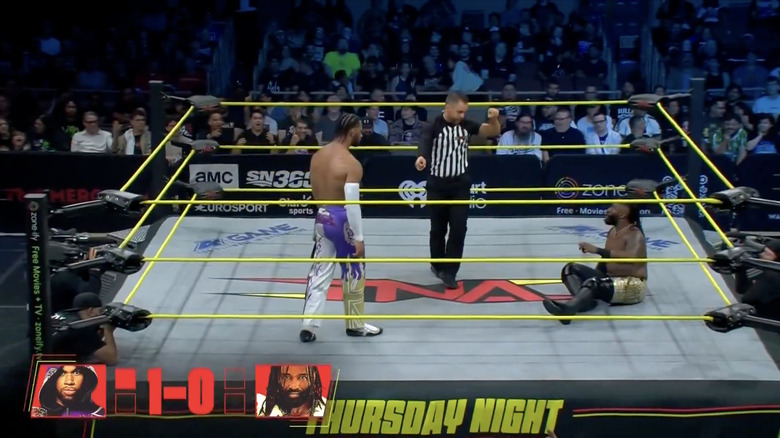 Slater standing over Alexander in the ring