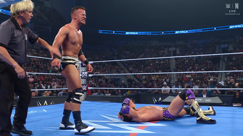 The referee about to raise Saints' hand as Cardona is laying on the mat