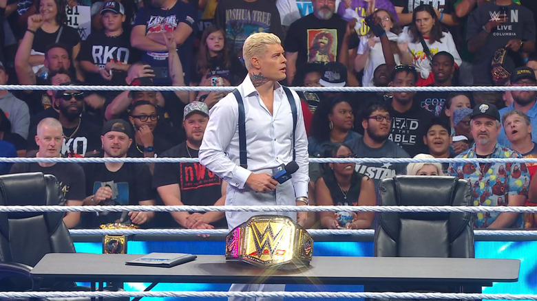 Rhodes standing in the ring with his Undisputed WWE Championship