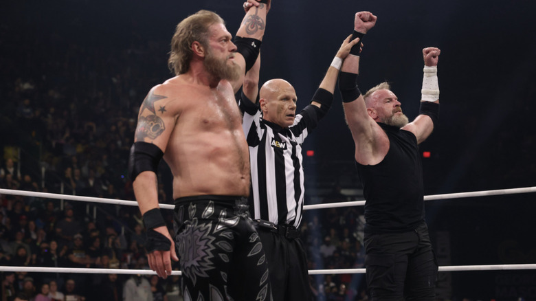 The referee raising Copeland and Cage's arms in the ring