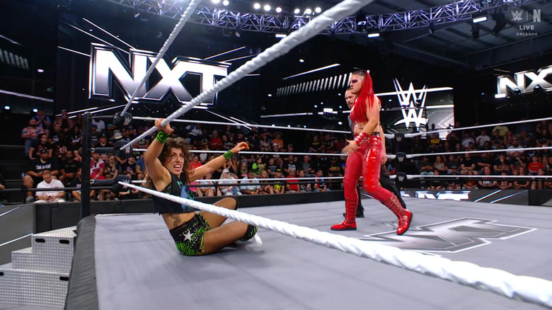 Zaria standing over Rain in the ring