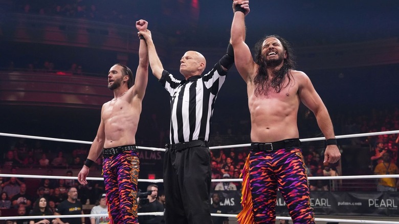 Young Bucks with their arms raised