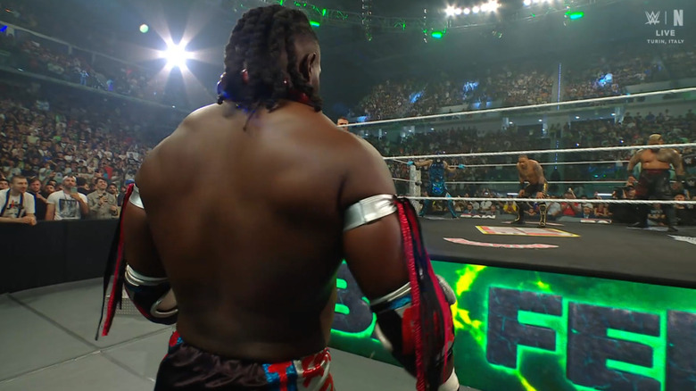 Femi staring down Penta, Hayes, and Sikoa in the ring