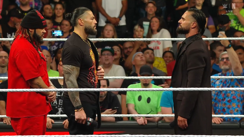 Reigns and Fatu staring down Rollins