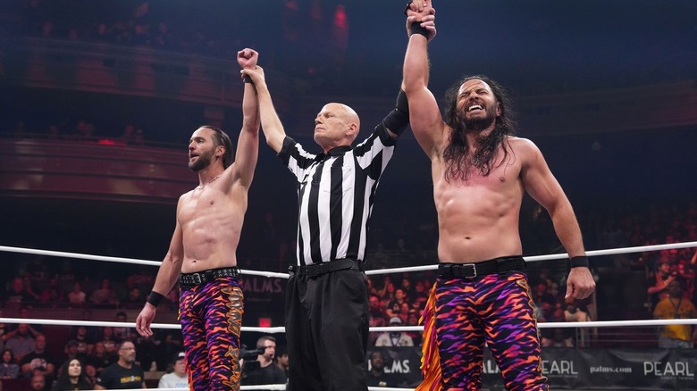 Young Bucks with their hands raised