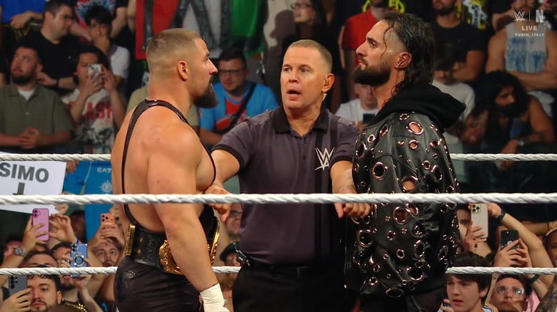 Breakker and Rollins staring down one another in the ring