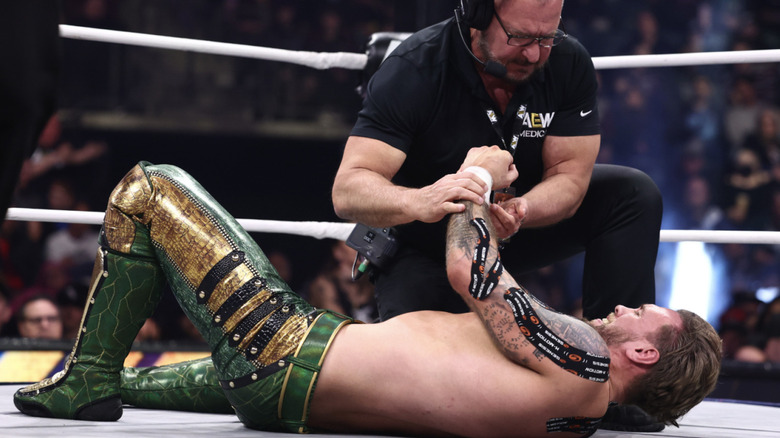 Ospreay being checked on in the ring by a medical offiical