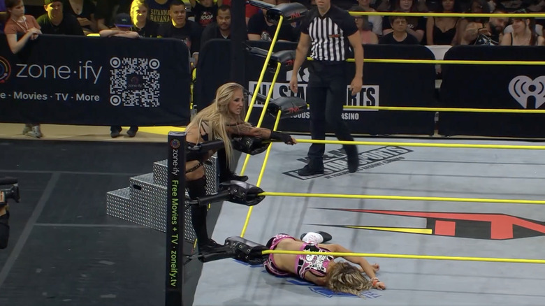 Heather climbing to the top rope as Allie is down on the mat