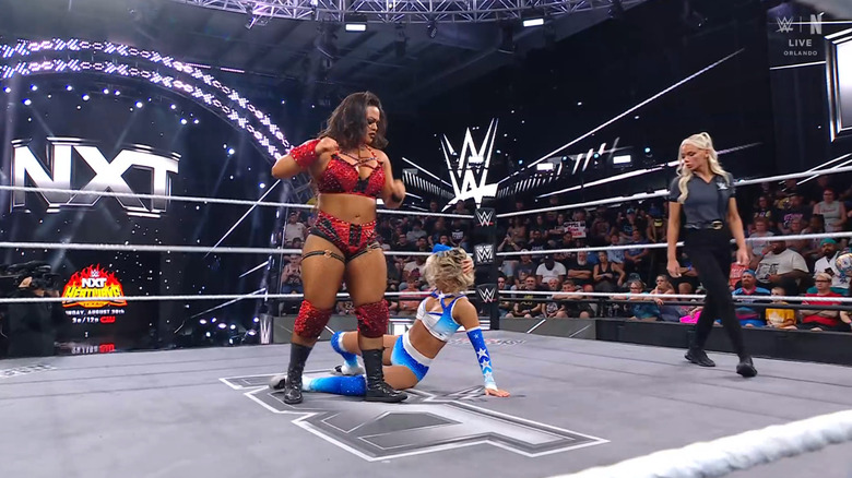 Volcan standing over Raye in the ring