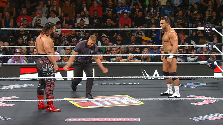 Fatu and Knight staring down one another in the ring