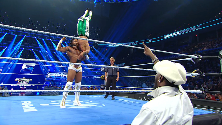 Williams with Hayes in a delayed vertical suplex position as Yachty watches from the outside