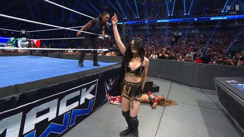 Paige standing over Nikki on the outside
