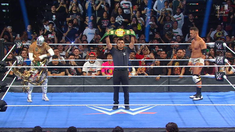 Fenix and Saints in the ring as the referee holds up the AAA Cruiserweight Championship