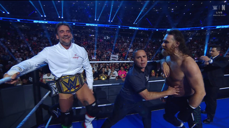 Zayn in Punk's face during the ring announcement as the referee holds him back